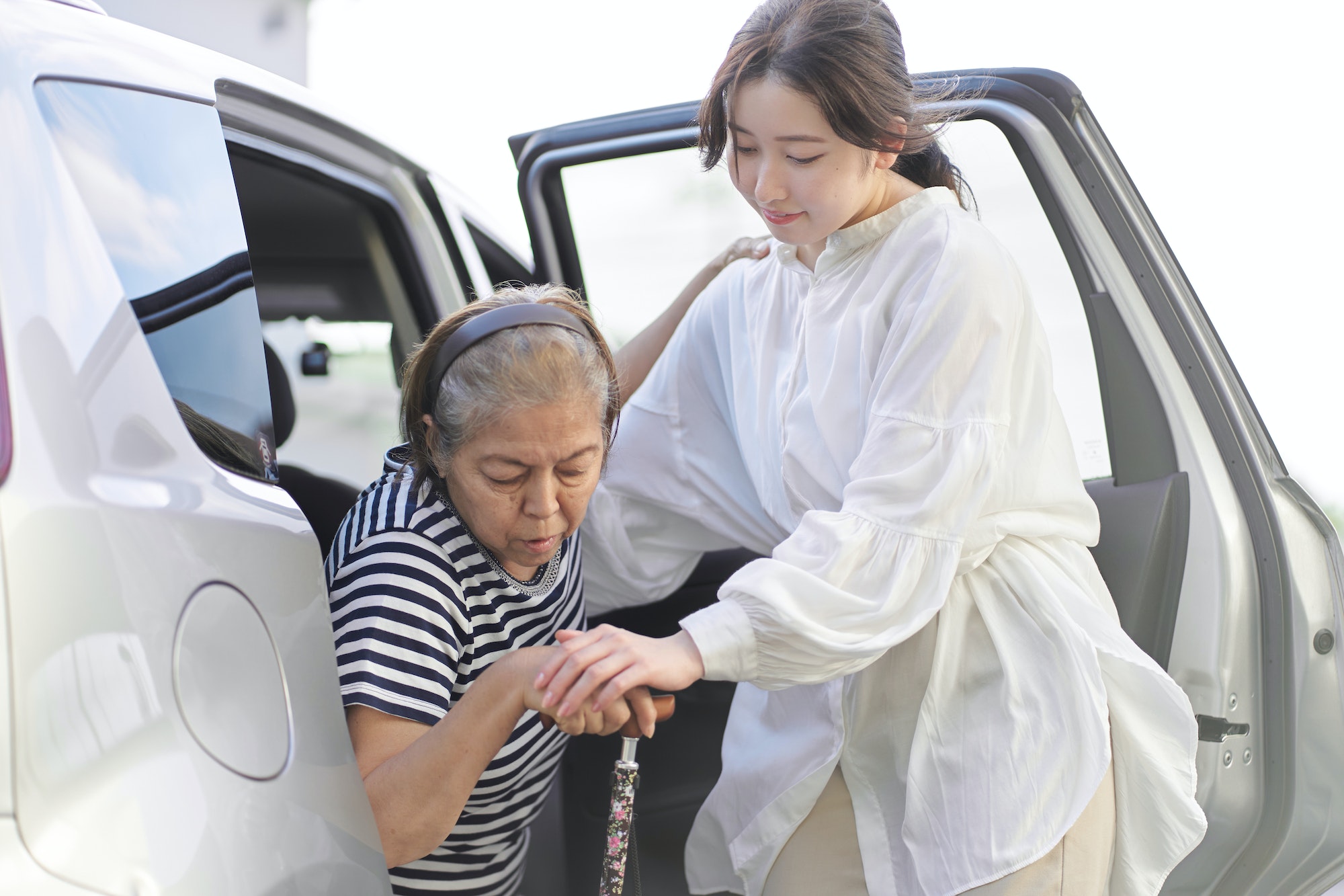 A woman who removes an elderly person from a car